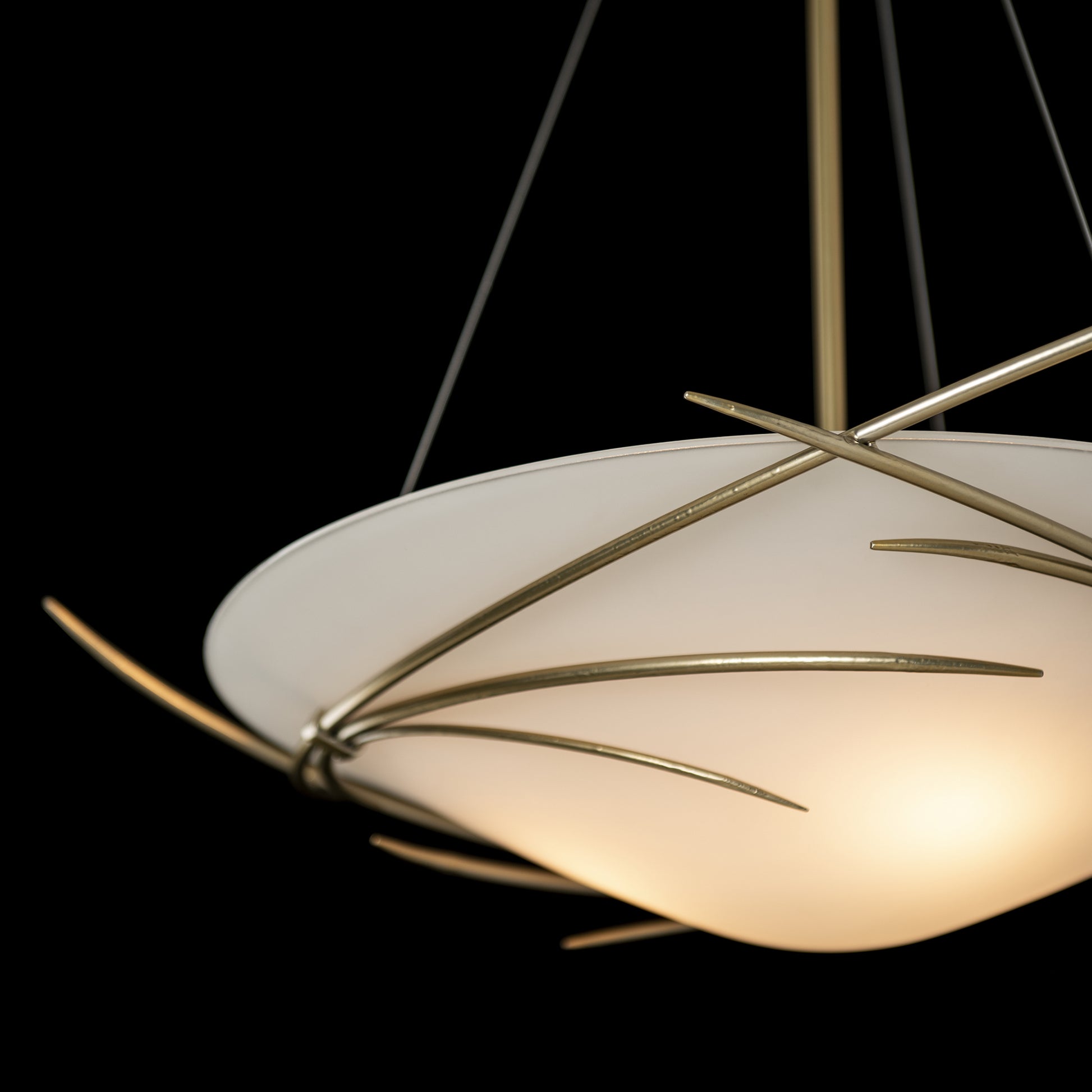The Hubbardton Forge Wisp Pendant is a stunning light fixture with a gold shade and branches, handcrafted by Hubbardton Forge.