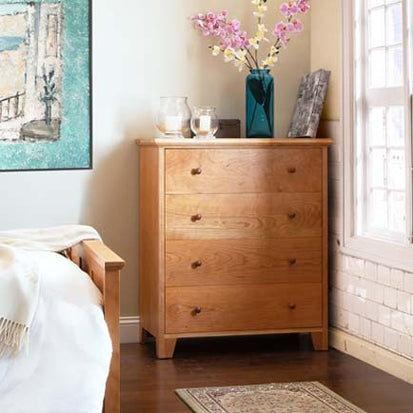 A bedroom with a wooden chest of drawers.