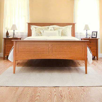 A bedroom with a wooden bed and hardwood floors.