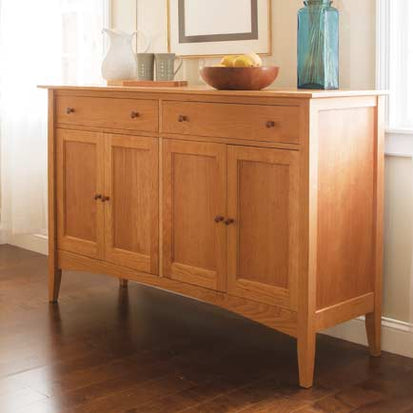 A wooden sideboard in a room with hardwood floors.