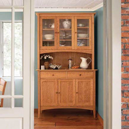 A hutch in a dining room with blue walls.