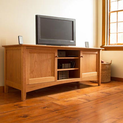 A tv stand in a room with hardwood floors.