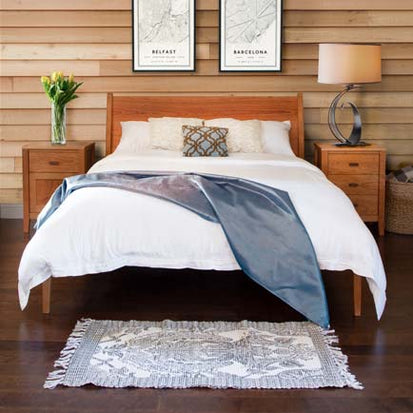 A bedroom with wooden walls and a bed.