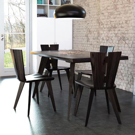 A dining table and chairs in a room with a brick wall.
