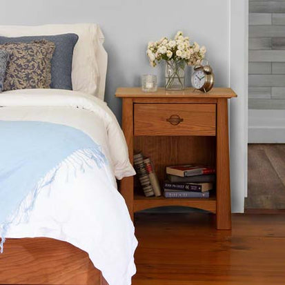 A bedroom with a bed, nightstand, and dresser.