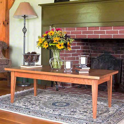 A living room with a fireplace and a coffee table.
