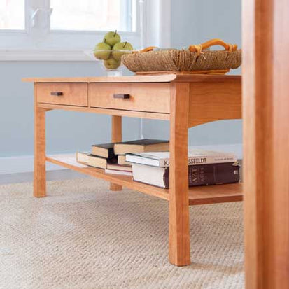 A coffee table in a living room with books on it.