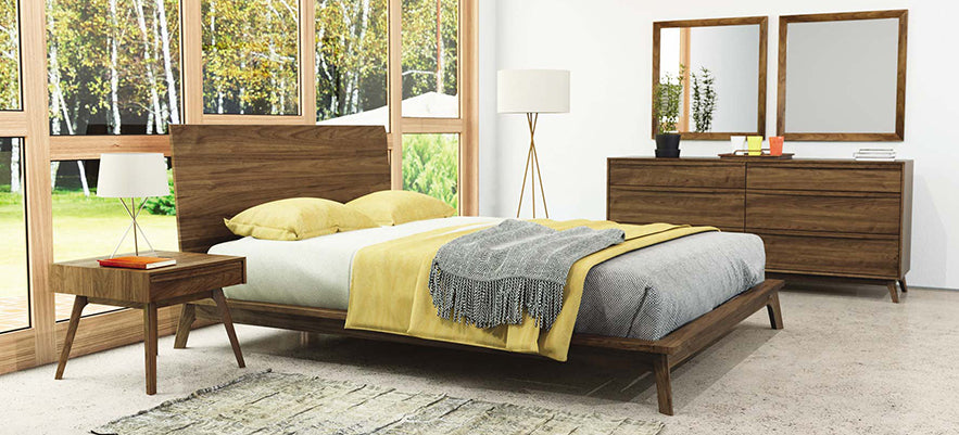 A bedroom with a bed, dresser and mirror.