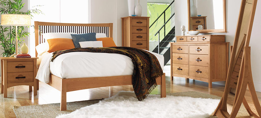 Wooden bed, nightstand, dresser, and mirror highlighting high-quality American craftsmanship.