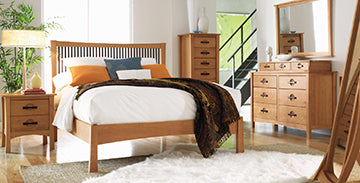 Wooden bed frame with matching side tables, tall chest of drawers, and dresser with mirror.