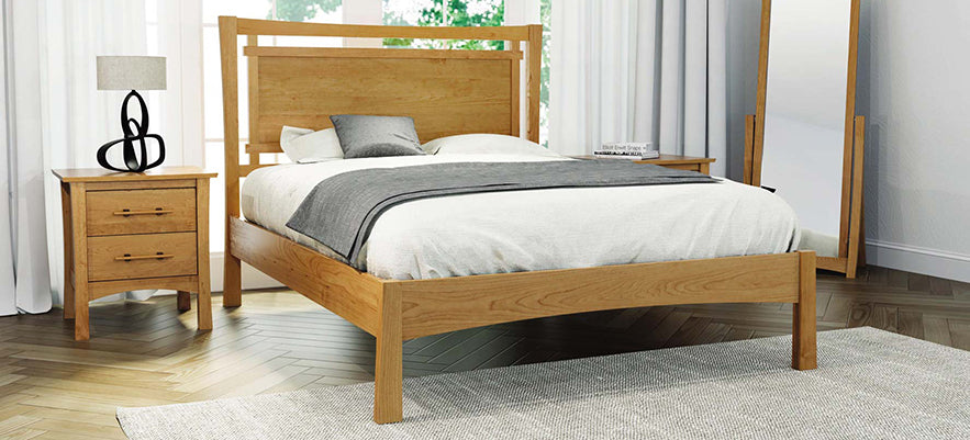 Wooden bed with white and gray bedding, flanked by two wooden nightstands featuring lamps; accompanied by a floor mirror.