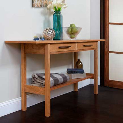 A wooden console table in a room with a door.