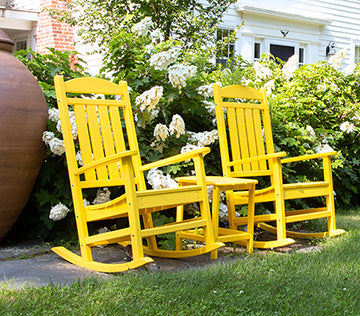 Bright yellow rocking chairs on a patio.