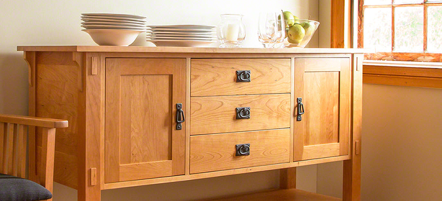 Wooden sideboard with two cabinets and three drawers.