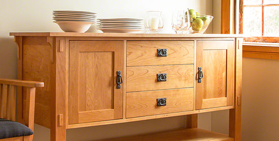 Wooden sideboard with two cabinets and three drawers.