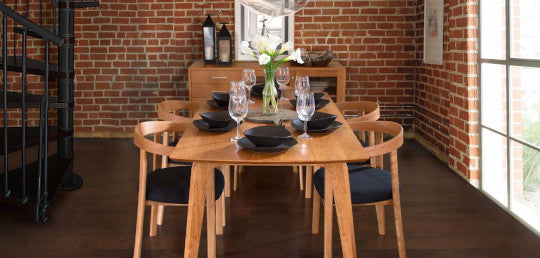 A dining room with brick walls and a wooden table.