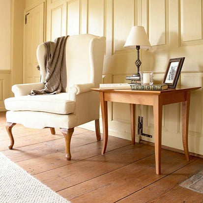 A chair and a table in a room with white walls.