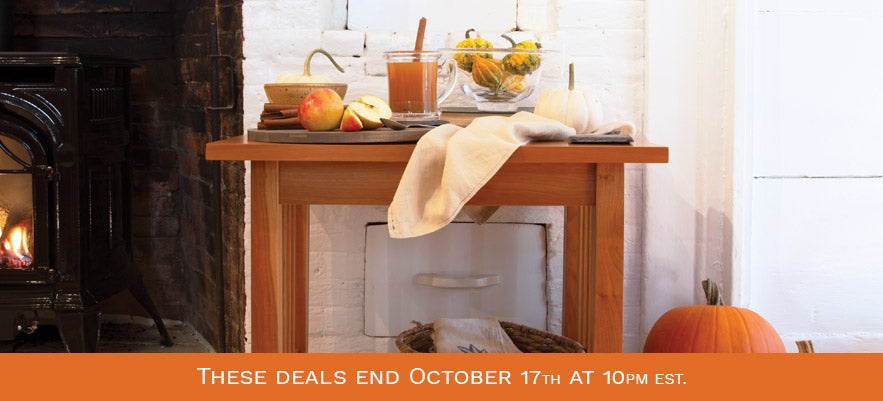 Wooden table showcasing apples, a drink, and pumpkins.