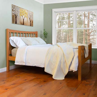 A bedroom with a wooden bed and green walls.