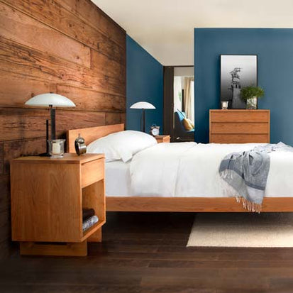 A bedroom with a wooden bed and blue walls.