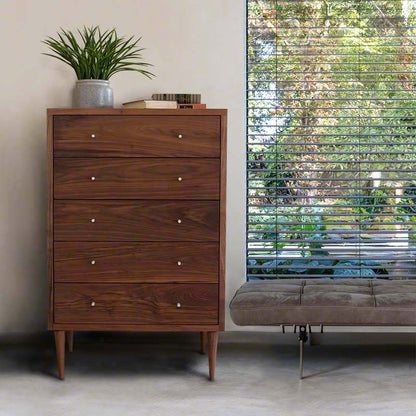 A Vermont Furniture Designs chest of drawers with a wood grain finish, situated in a room with a window.