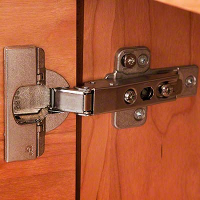 An image of a kitchen cabinet with a hinge on it.