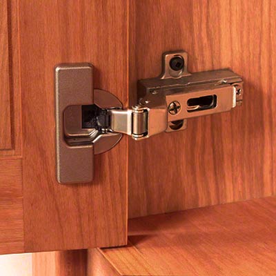 An image of a cabinet door with a hinge on it.
