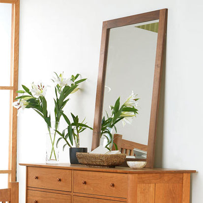 A wooden dresser with a mirror.
