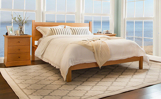 Large wooden bed with headboard and matching nightstand.