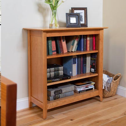 A wooden bookcase in a living room.
