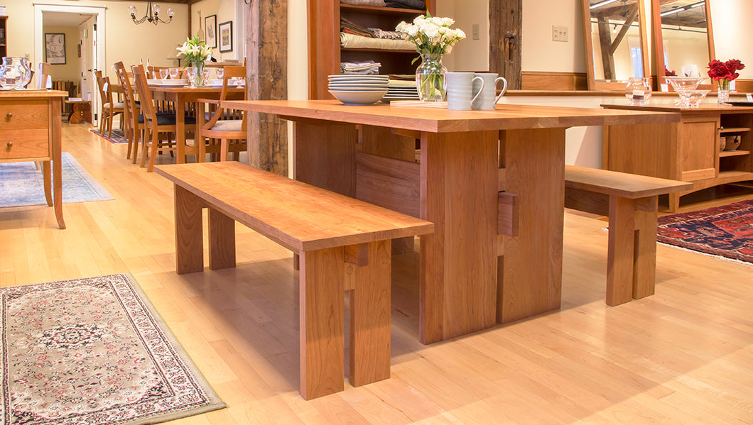 A wooden dining table with matching benches.