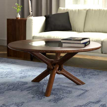 A coffee table in a living room with a blue rug.