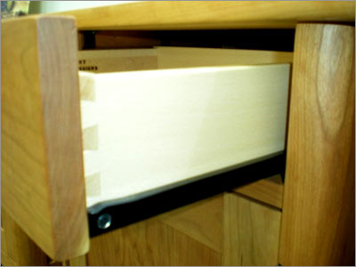 A drawer is open in a wooden cabinet.