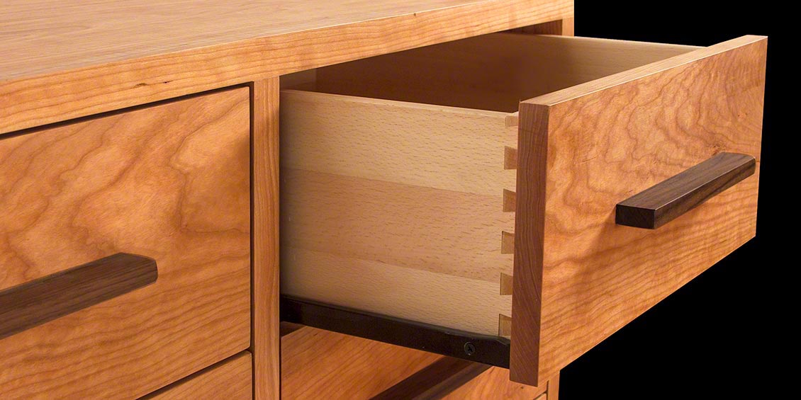 A close up of a wooden dresser with drawers.