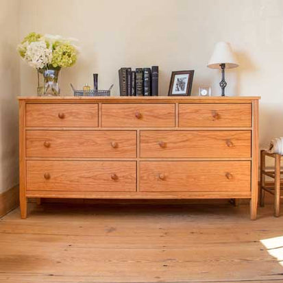 A wooden dresser in a room with wooden floors.