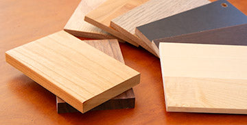 A variety of wood veneers on a wooden table.