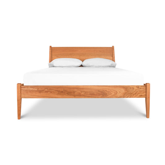 A wooden bed with white sheets on it.