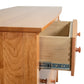 A wooden dresser with a drawer open.