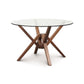 A modern dining table with a glass top and wooden legs.