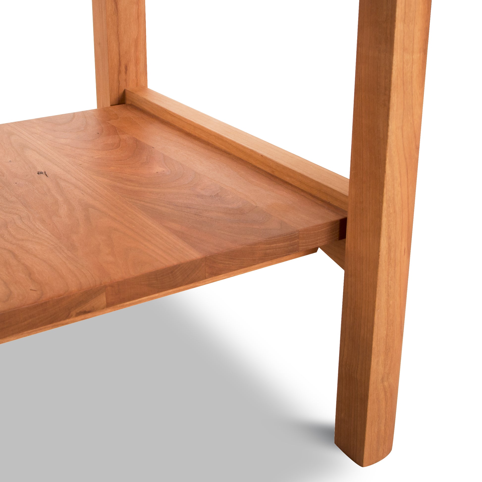 A close up of a wooden table with a shelf.