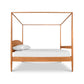 A wooden canopy bed with a white sheet.