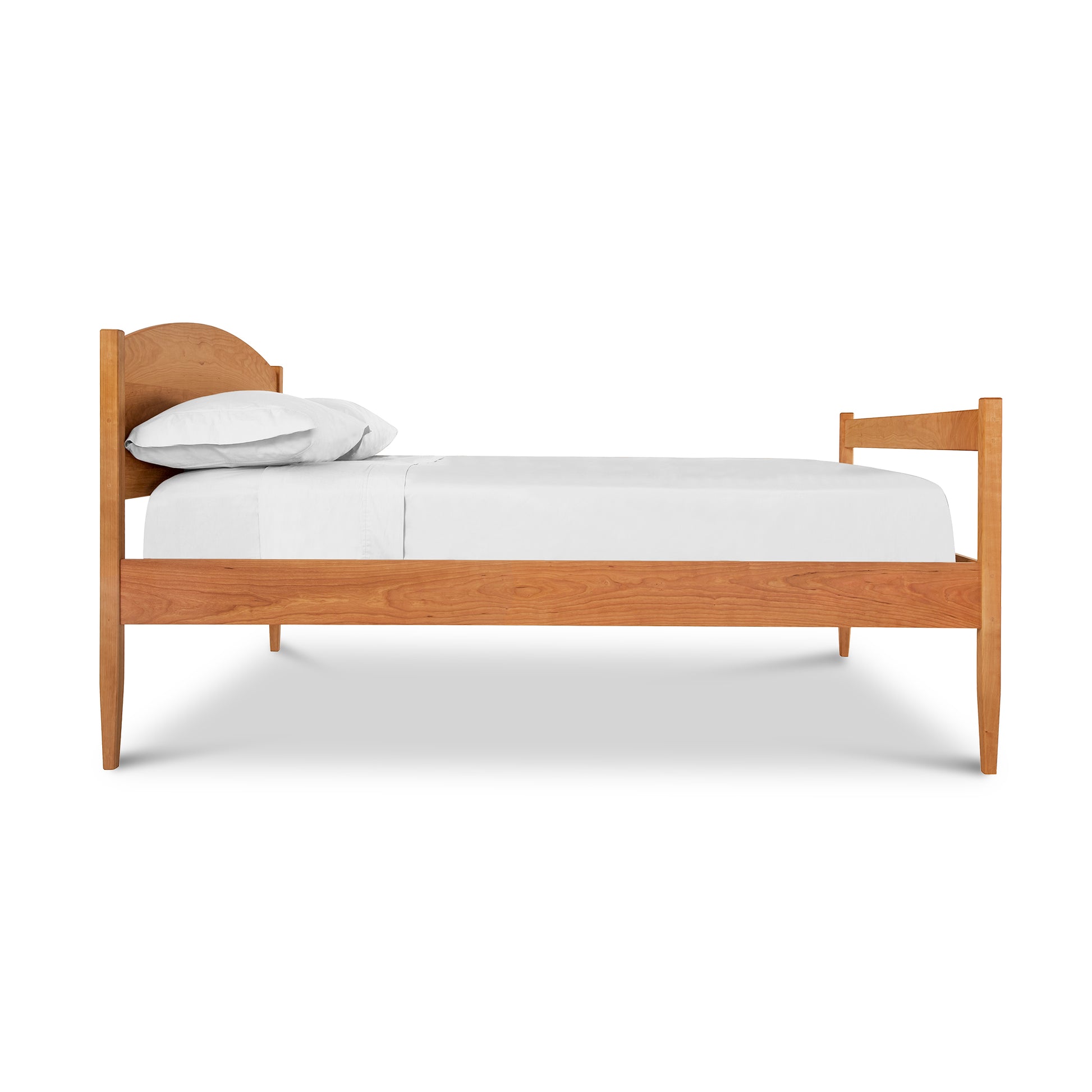 A wooden bed with a white sheet on it.
